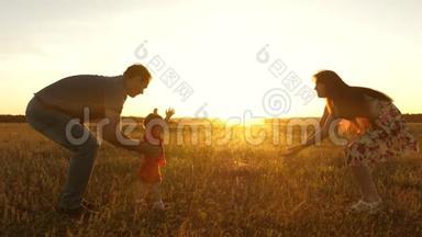 爸爸和妈妈在阳光下和一个小女儿在野外玩耍。 小女儿在阳光下从爸爸变成妈妈。 母亲
